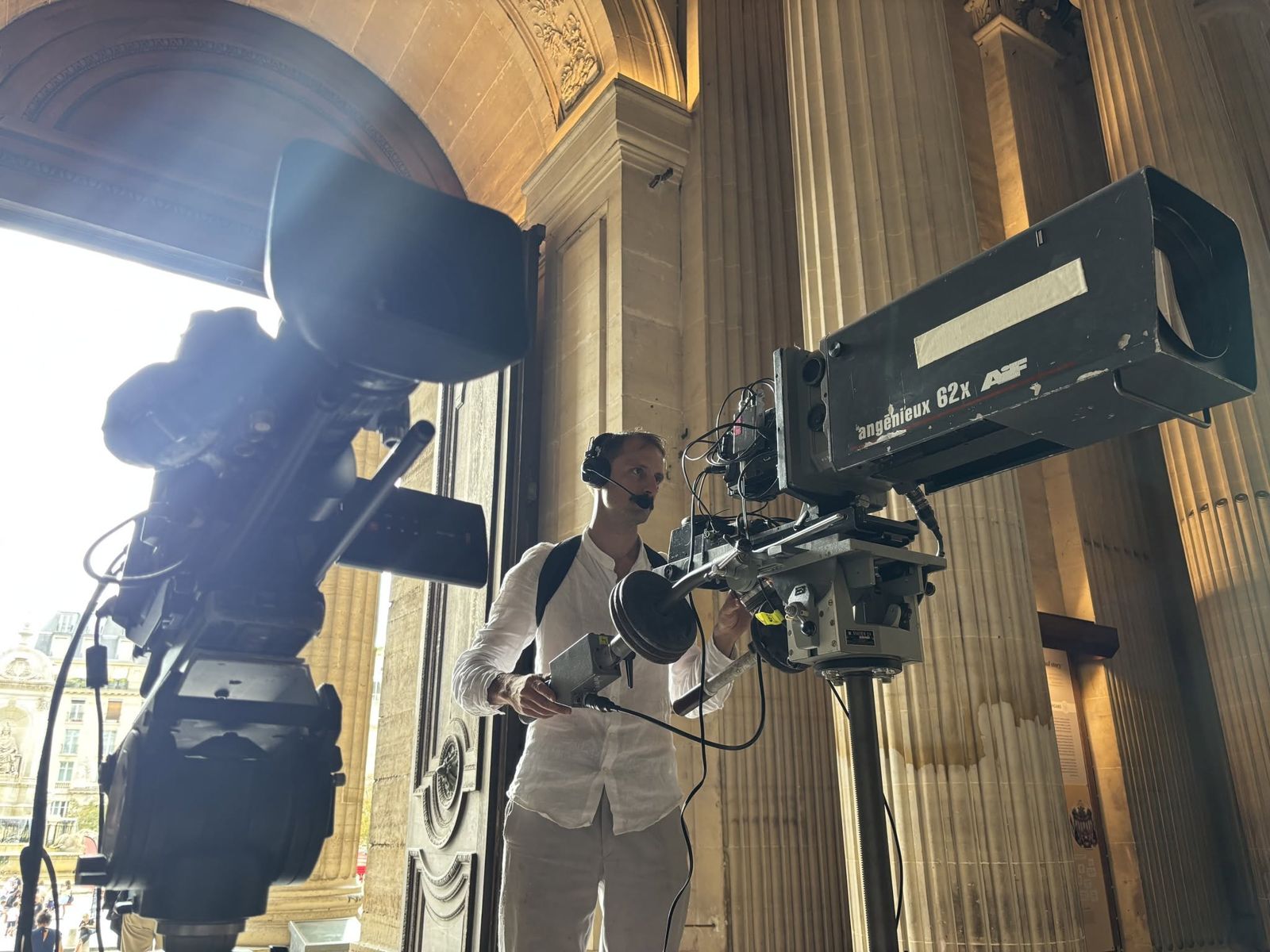 Caméra broadcast avec longue focale sous une colonnade
